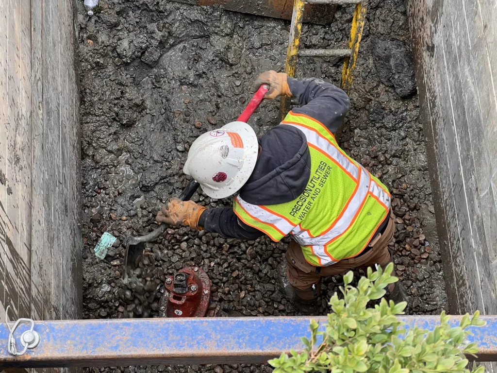 Underground utility worker fixing sewer pipe